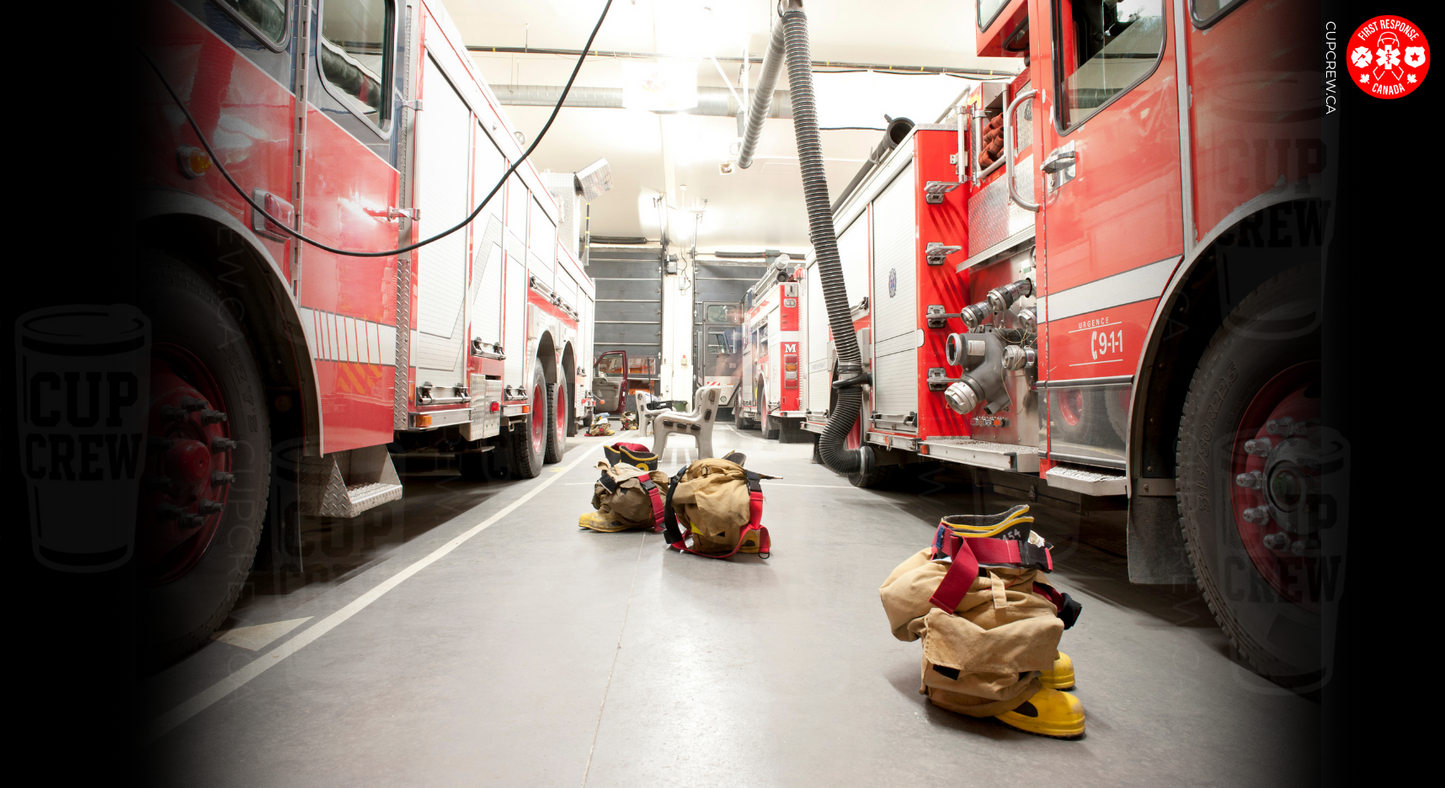 a fire station with two fire trucks parked side by side. There are several firefighting gear items, such as helmets, bags, and other equipment, scattered around the area.