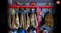 A fire station's firefighting equipment is neatly organized on a red rack, with various fire helmets and jackets hanging on it.